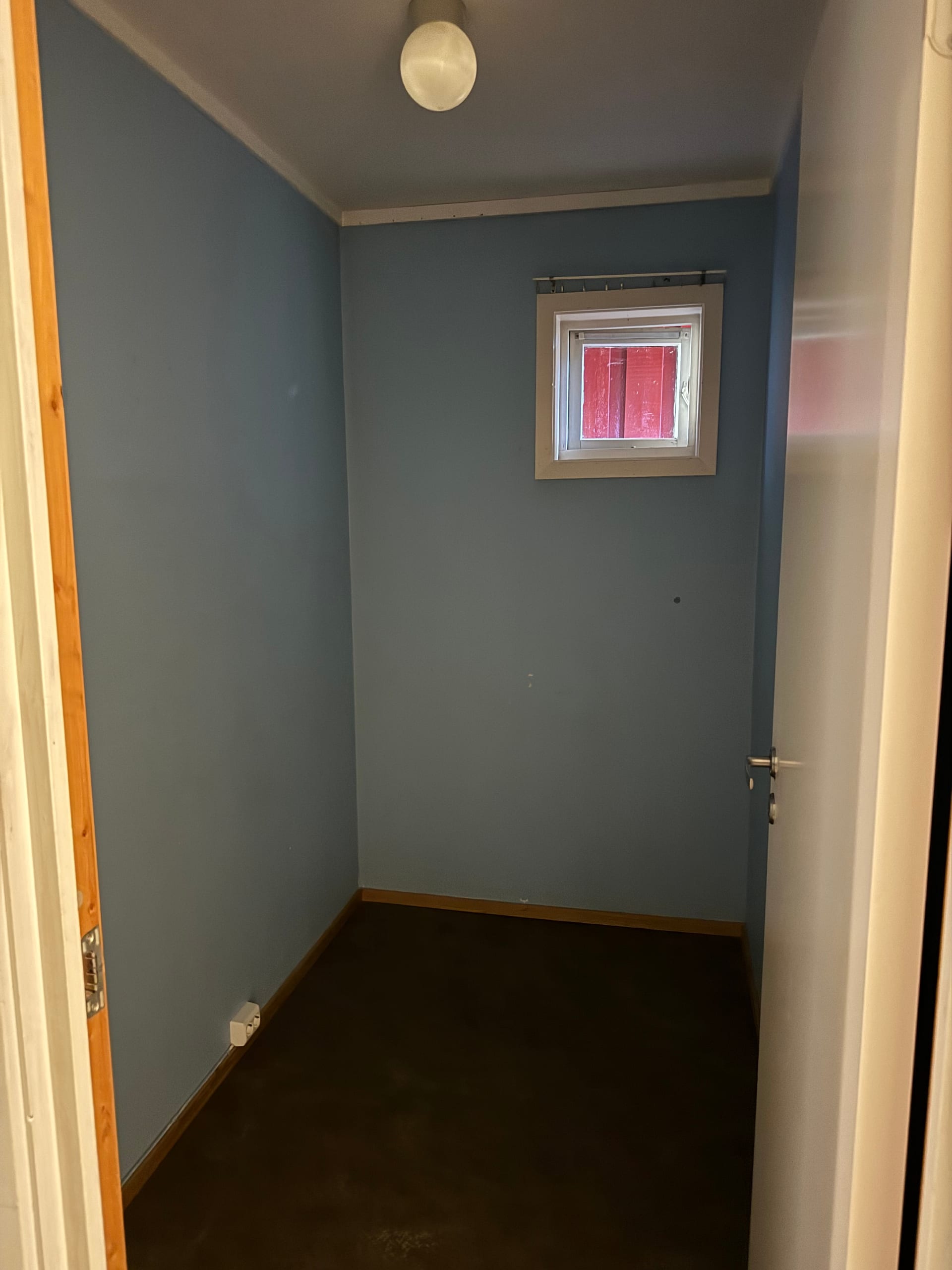 Lite rom med blå vegger og vindu